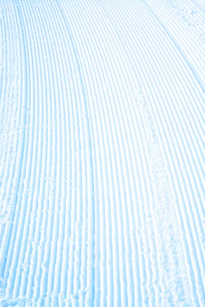 Paski na powierzchni śniegu profilowane pod kątem przyszłego szlaku narciarskiego. — Zdjęcie stockowe