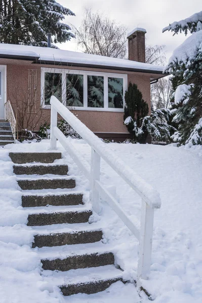 Schody do wejścia do domu rodzinnego nad dziedzińcem w śniegu — Zdjęcie stockowe