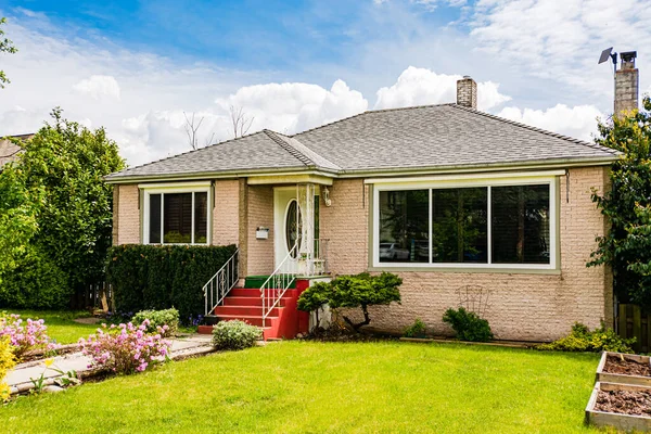 Modest family house with green lawn in front