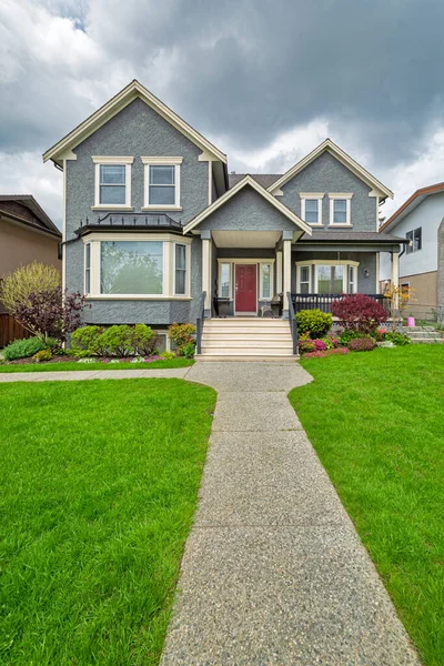 Nice family house with concrete pathway over green lawn over front yard — Stock Photo, Image