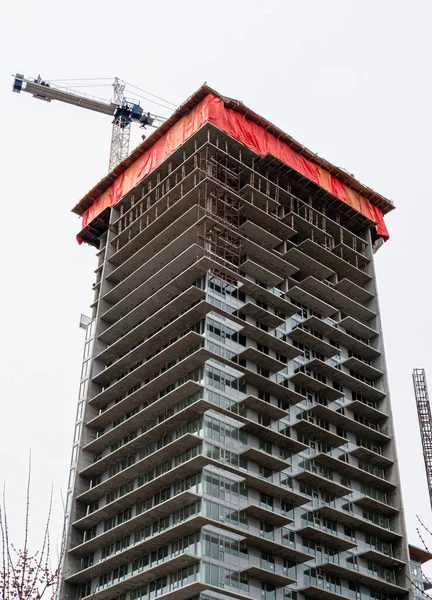 Edificio de hormigón monolito de gran altura con la grúa por encima — Foto de Stock