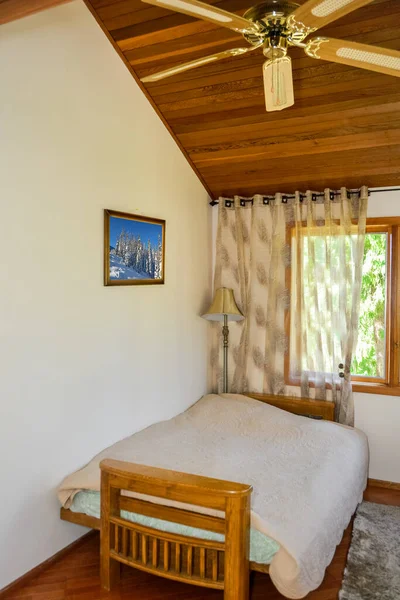 Mała, lekka sypialnia z zasłonami na oknach i dywanem na podłodze. — Zdjęcie stockowe