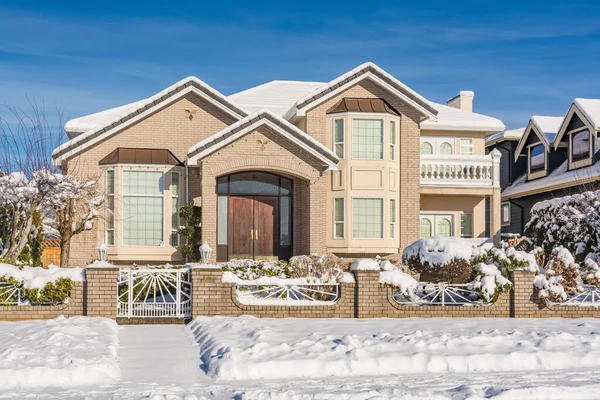 Luksusowy dom mieszkalny z podwórkiem w śniegu w zimowy słoneczny dzień — Zdjęcie stockowe