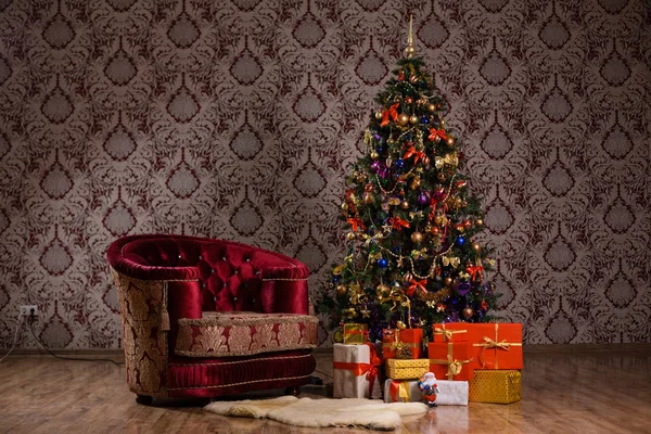 Тёмная рождественская сцена с ёлкой, подарками и креслом — стоковое фото