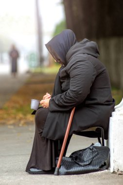 Ryazan, Rusya - 07.09.2019: Siyahlı yaşlı kadın bir sandalyede oturuyor ve sokakta sadaka istiyor