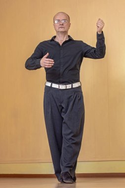 Stüdyodaki şehvetli esnek adamlar klasik bir pozda tango eğitip dans ediyorlar. Tango eğitimi konsepti, erkek partisi