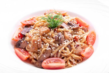 Kiraz domatesli İtalyan makarnası, mantar, susam ve dereotu yuvarlak tabakta. Yukarıdan bak. beyaz üzerine izole