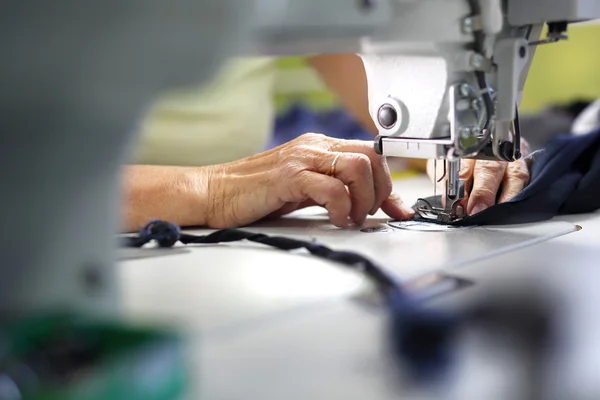 Produção de roupas, costura em uma máquina — Fotografia de Stock