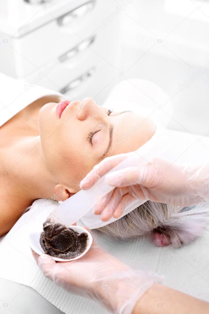 Cleansing mask, a woman in the beauty salon.