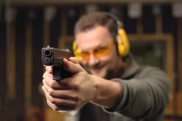 Frau schießt mit Waffe auf Schießstand. — Stockfoto