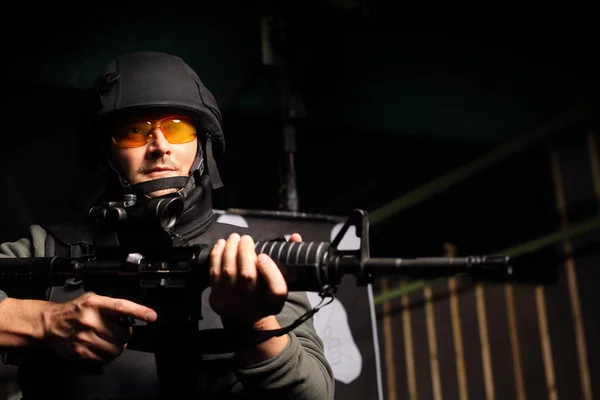 Hombre con un chaleco disparado al campo de tiro con un rifle — Foto de Stock