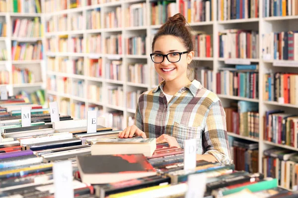 Schoolmeisje in de bibliotheek. — Stockfoto