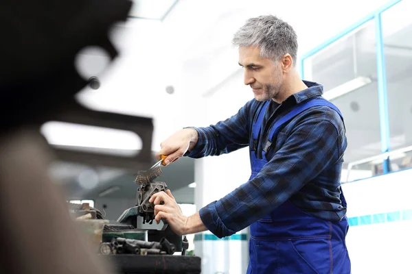 Garage, ein Mann repariert ein Auto. — Stockfoto