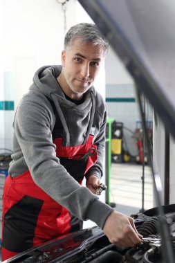 İş yerinde bir adam arabayı tamir