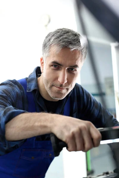 Autowerkstatt, gutaussehender Mechaniker bei der Arbeit. — Stockfoto