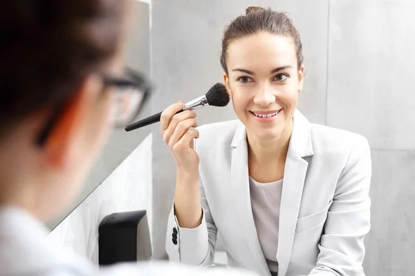 Trabalho de maquilhagem. Mulher de negócios atraente melhora a maquiagem no banheiro da empresa — Fotografia de Stock