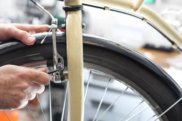 Cykelverkstad, mekaniker utbyten ekrar. — Stockfoto