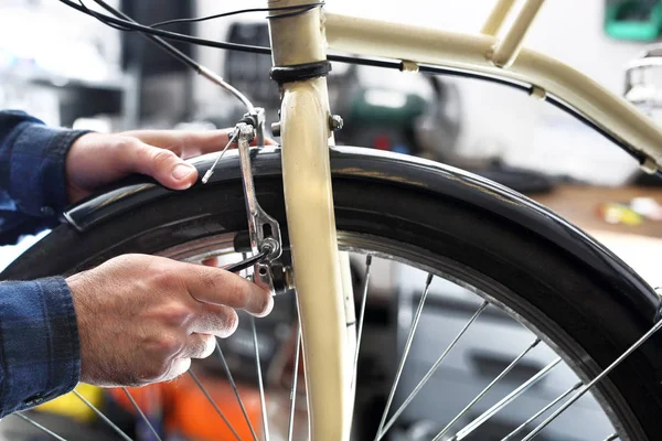 Cykelverkstad, mekaniker utbyten ekrar. — Stockfoto