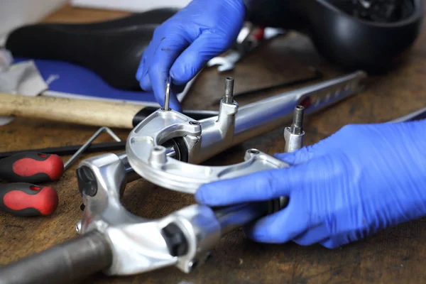 Serviceman. The man repairs the bike. — Stock Photo, Image