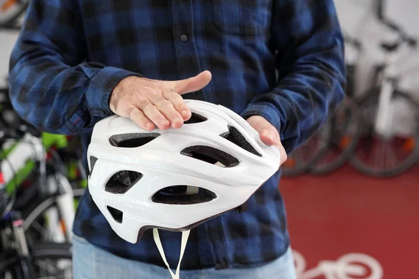 Bisiklet satıcı bir bisiklet salonda bir kask seçmek için yardımcı olur. — Stok fotoğraf