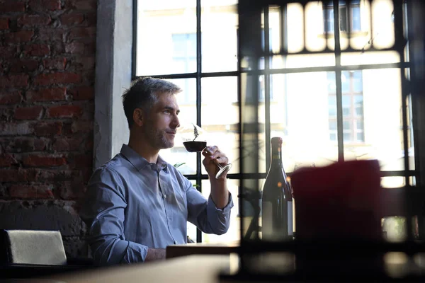 Bonito homem de meia-idade bebendo vinho . — Fotografia de Stock