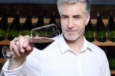 Kırmızı şarap. Adam bir restoranda şarap içme