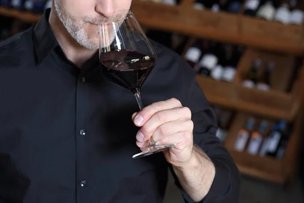 Aroma de vino. Un hombre huele un ramo de vino tinto dado por un camarero . — Foto de Stock