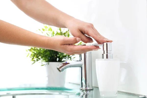 De handen van de vrouw in de badkamer. — Stockfoto