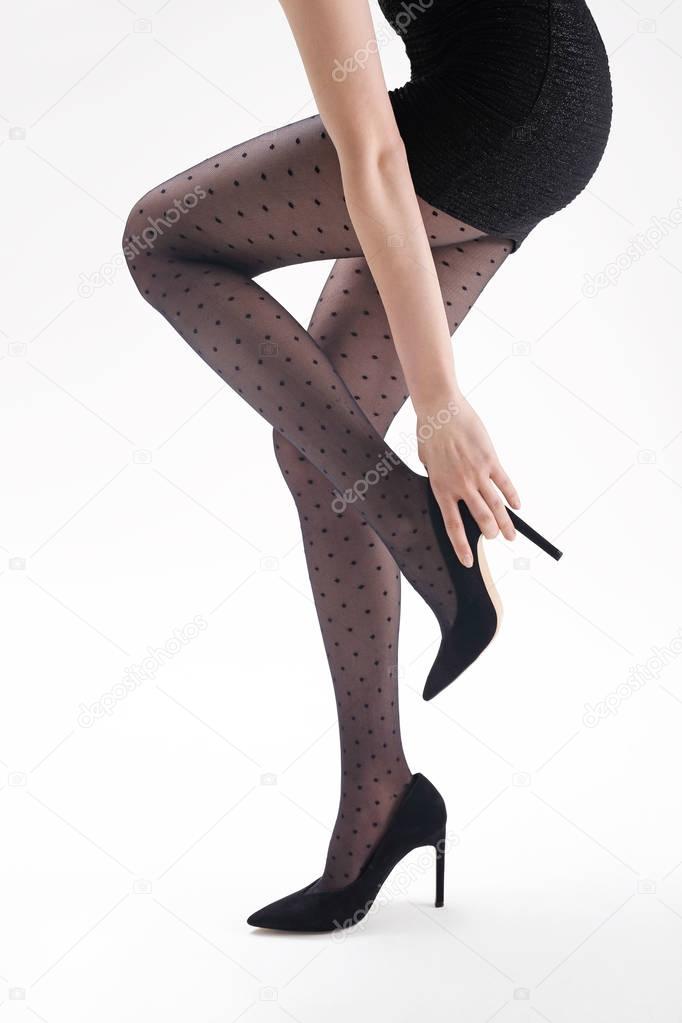 Tights. Shapely female legs in black tights and high heels.