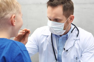 Çocuk bir doktor ile. Çocuk doktoru inceliyor.