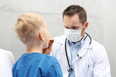 Hasta çocuk doktora. Çocuk doktoru inceliyor.