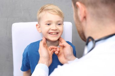Otolaryngologist, bir doktor bir çocukla. Çocuk çocuk doktoru, tıbbi muayene ofisinde