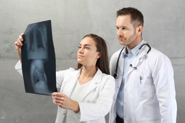 Doctors are looking at the patient's x-ray picture. clipart