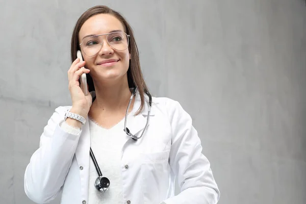 Lekarz Jest Rozmowa Telefon Lekarz Ubrany Biały Kombinezon Stoi Klinice — Zdjęcie stockowe