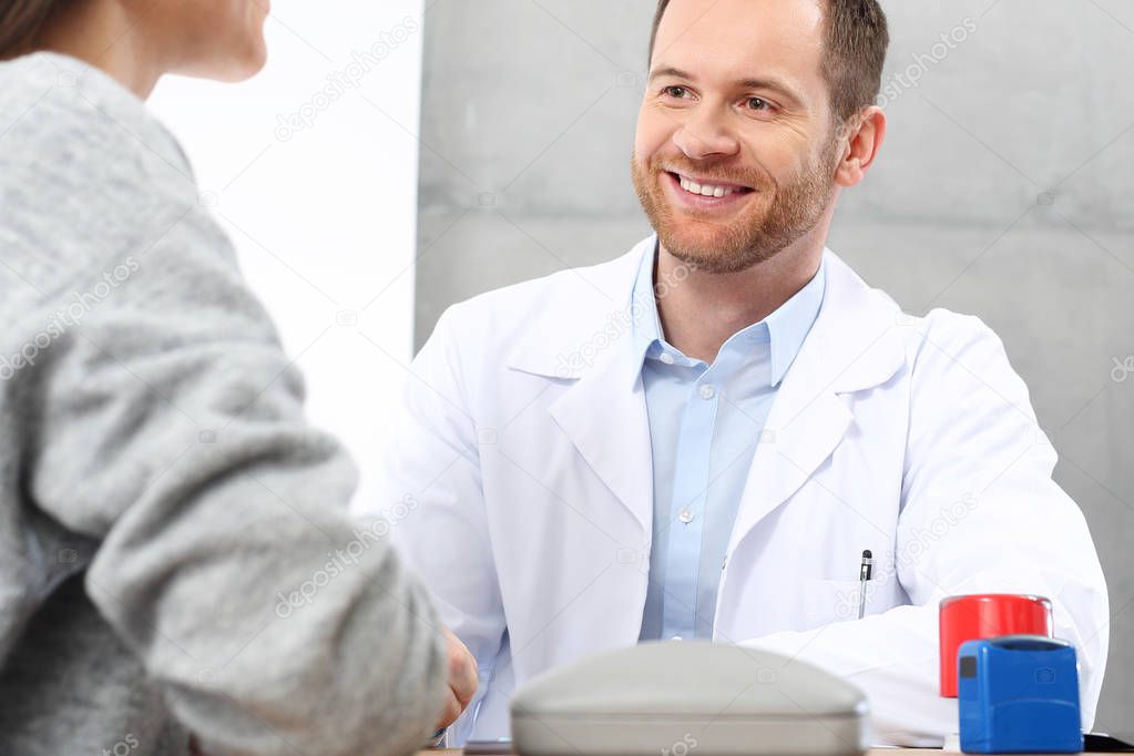 The doctor gives the prescription to the patient.