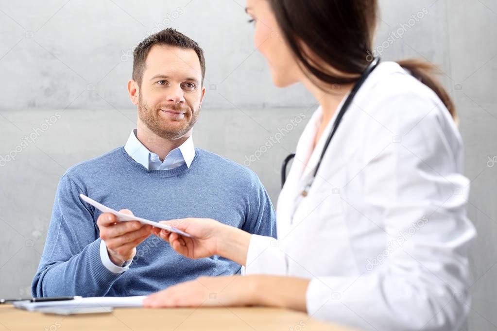 Patient in a doctor's office.. The doctor enters recommendations and prescriptions.