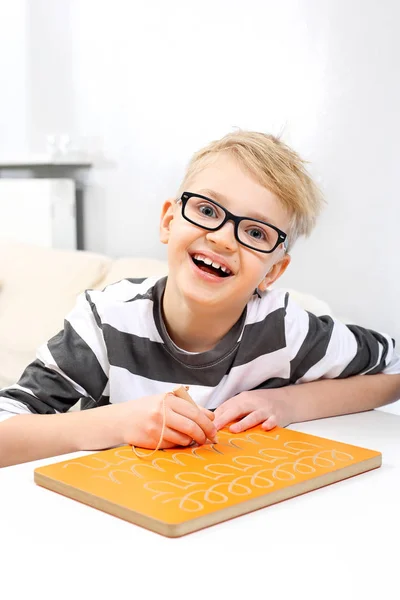Mały Uczeń Uśmiechnięty Chłopiec Ćwiczyć Pisanie Listów — Zdjęcie stockowe