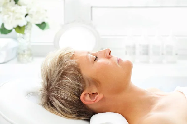 Relax in the spa. Beautiful middle-aged woman during a beauty treatment in a beauty salon.