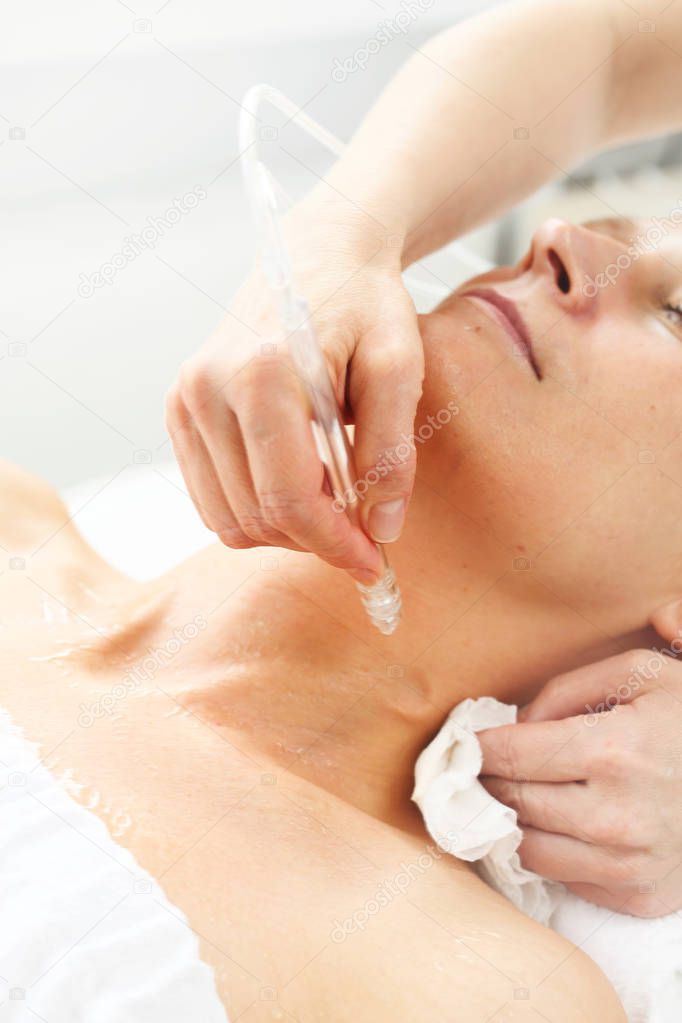 Oxygen oxybrasion. Smooth neck and cleavage. The beautician performs oxygen oxybrasion treatment on the skin of the neckline and neck of a woman. Care treatment, skin cleansing