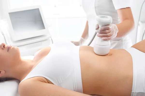 Soulèvement du ventre. Une femme dans une clinique cosmétique lors d'un massage raffermissant sur la peau de l'abdomen . — Photo