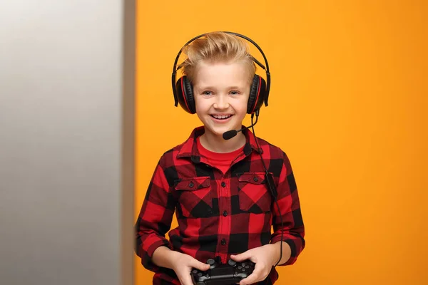 Çocuk Kulaklıkla Video Oyunu Oynuyor Sarı Arka Planda Kırmızı Gömlekli — Stok fotoğraf