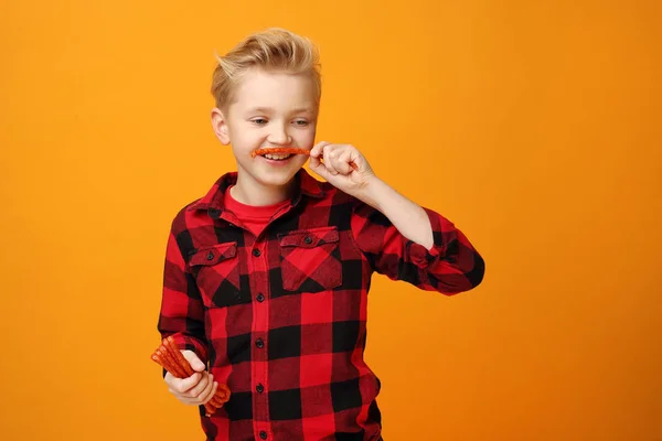 Çocuk Kuru Sosis Yiyor Sarı Arka Planda Kırmızı Gömlekli Gülümseyen — Stok fotoğraf