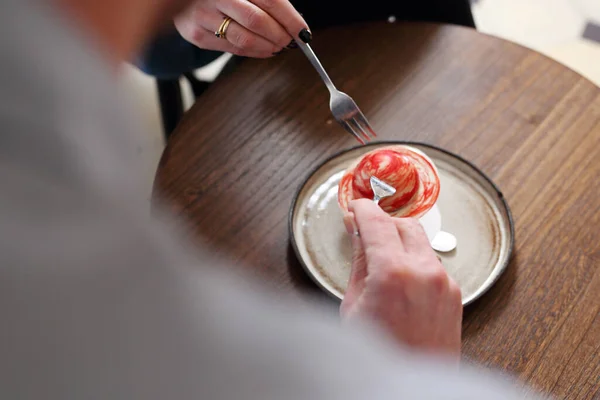 Sweet dessert. A woman and a man are eating sweet dessert hearts.