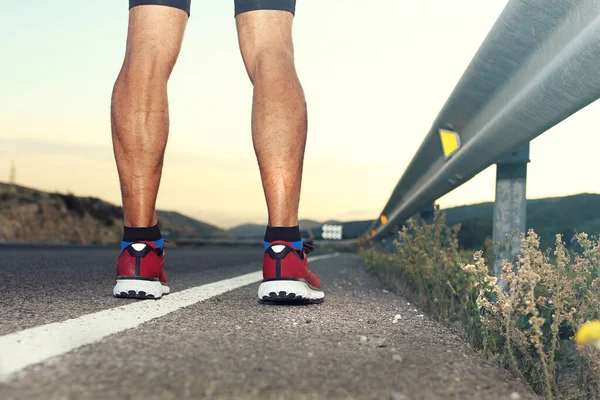 Professional running shoes. A man in sports outfit runs along the road.