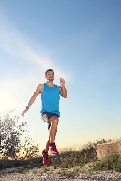 Jogging. A man in sports outfit runs along the mountain trail.