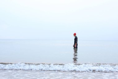 Denizde yüzen bir adam var. Termal köpüklü adam denizde su sporları yapıyor..