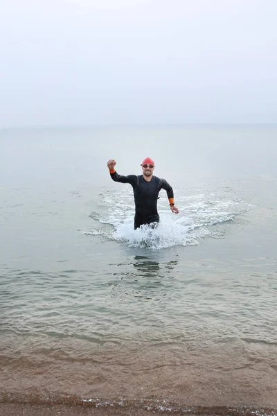 Swimming in the sea, a man swims. The man in thermal foam does water sports in the sea.