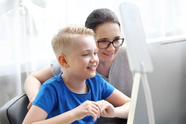 Distance learning. Mum helps the child learn online.The child learns via the internet, online lesson.