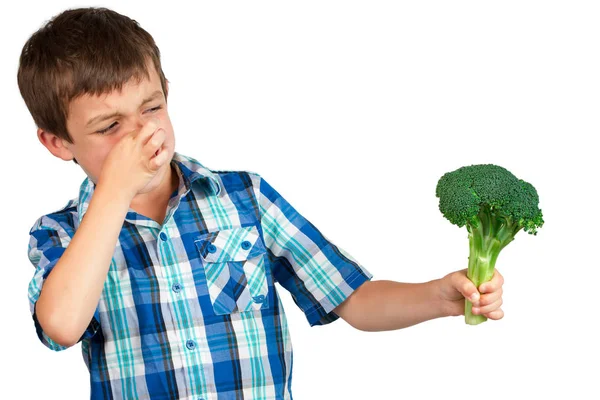 Chłopiec ogląda brokuły z obrzydzeniem — Zdjęcie stockowe