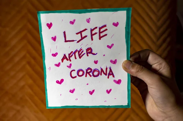 被一个女人牵着手拿着并展示的Covid Coronavirus海报后的生活 — 图库照片